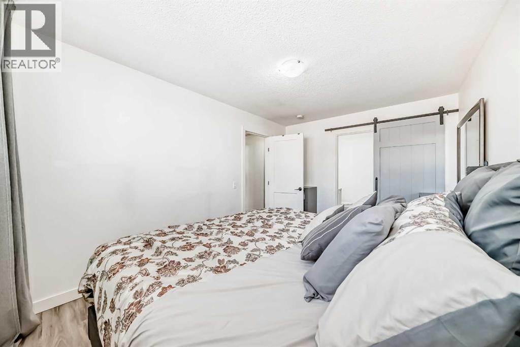 Barn door separates 2d pc ensuite - 216 Pinecrest Crescent Ne, Calgary, AB - Indoor Photo Showing Bedroom