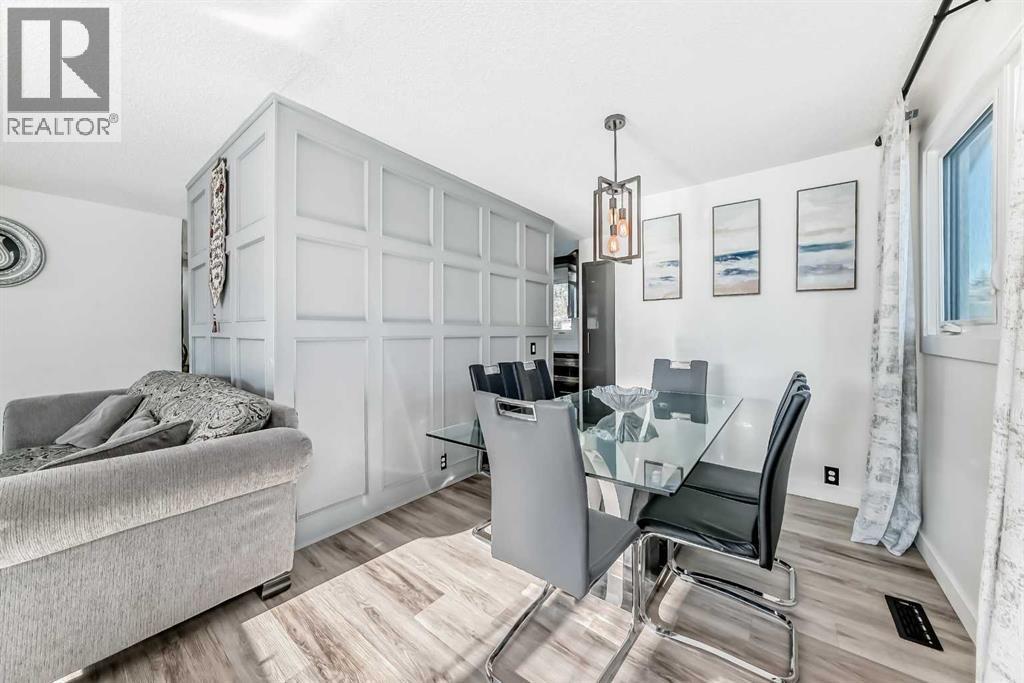Dining room with feature wall connects to the kitchen - 216 Pinecrest Crescent Ne, Calgary, AB - Indoor Photo Showing Dining Room