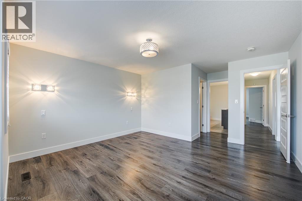 Unfurnished bedroom featuring dark wood-type flooring and baseboards - 2527 Holbrook Drive, London, ON - Indoor Photo Showing Other Room