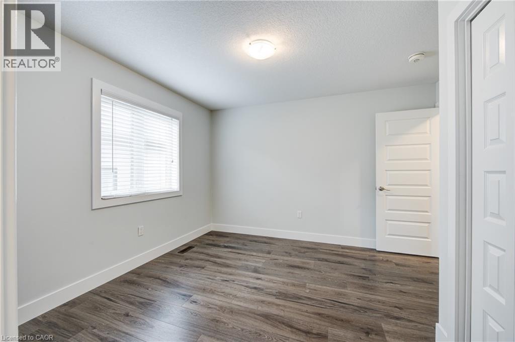 Empty room featuring a textured ceiling and dark wood-style flooring - 2527 Holbrook Drive, London, ON - Indoor Photo Showing Other Room