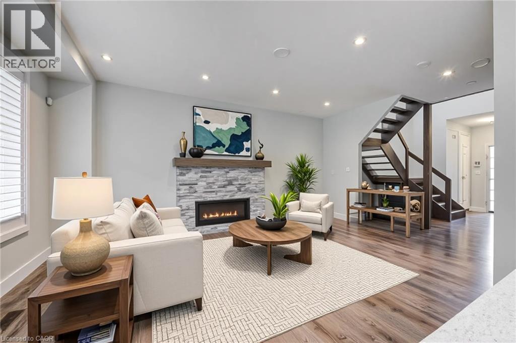 Living area featuring stairs, wood finished floors, a fireplace, and recessed lighting - 2527 Holbrook Drive, London, ON - Indoor Photo Showing Living Room With Fireplace