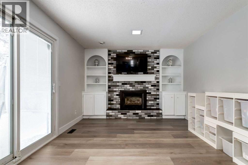 16 Woodgate Close Sw, Calgary, AB - Indoor Photo Showing Living Room With Fireplace
