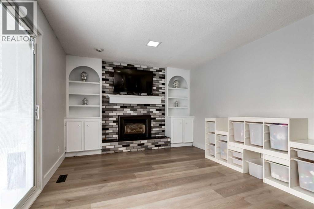 16 Woodgate Close Sw, Calgary, AB - Indoor Photo Showing Living Room With Fireplace