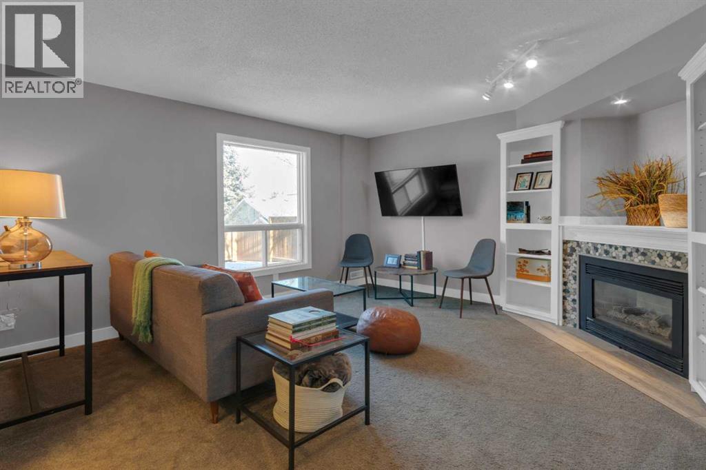 RECREATION ROOM - 40 Hunters Gate, Okotoks, AB - Indoor Photo Showing Living Room With Fireplace