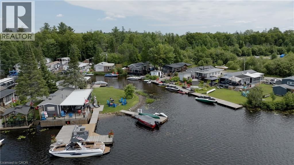 Aerial perspective of suburban area featuring a large body of water - 85 Hutchinson Beach Road Unit# B56, Huntsville, ON - Outdoor With Body Of Water With View