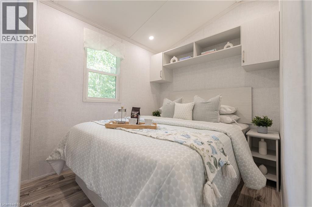 Bedroom featuring vaulted ceiling, recessed lighting, wood finished floors, and crown molding - 85 Hutchinson Beach Road Unit# B56, Huntsville, ON - Indoor Photo Showing Bedroom
