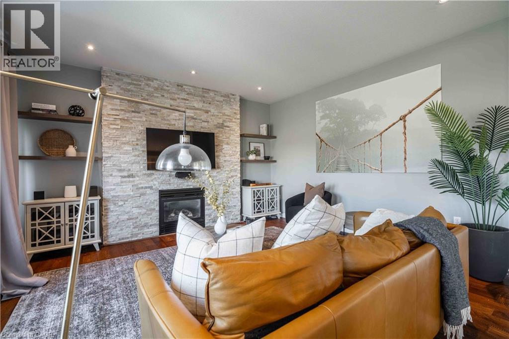 Family Room featuring Engineered hardwood finished floors, a stone fireplace, and recessed lighting - 51 Showcase Drive, Hamilton, ON - Indoor Photo Showing Living Room With Fireplace