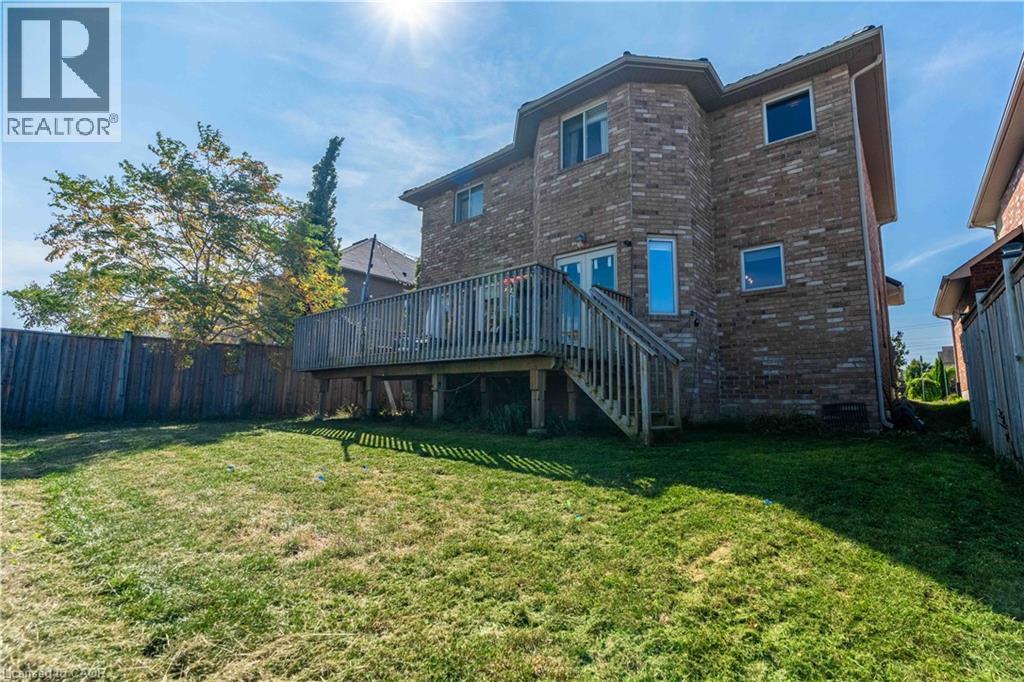 Rear view of house with brick siding, a wooden deck, and stairway - 51 Showcase Drive, Hamilton, ON - Outdoor With Deck Patio Veranda