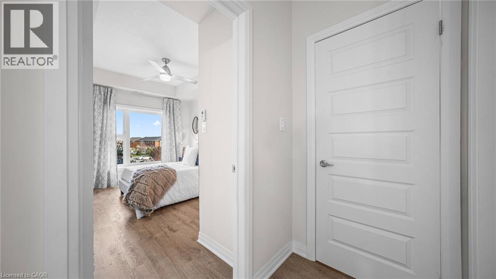 Bedroom with wood finished floors and ceiling fan - 610 Farmstead Drive Unit# 304, Milton, ON - Indoor