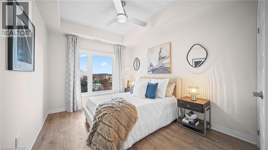 Bedroom with wood finished floors, ceiling fan, and a tray ceiling - 610 Farmstead Drive Unit# 304, Milton, ON - Indoor Photo Showing Bedroom