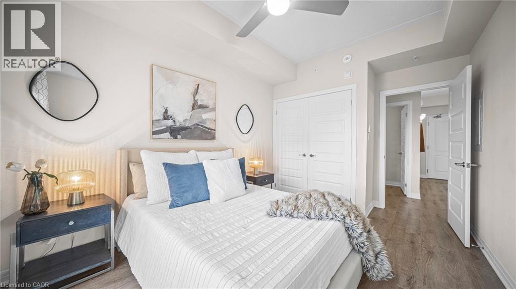 Bedroom with wood finished floors, ceiling fan, and a closet - 610 Farmstead Drive Unit# 304, Milton, ON - Indoor Photo Showing Bedroom
