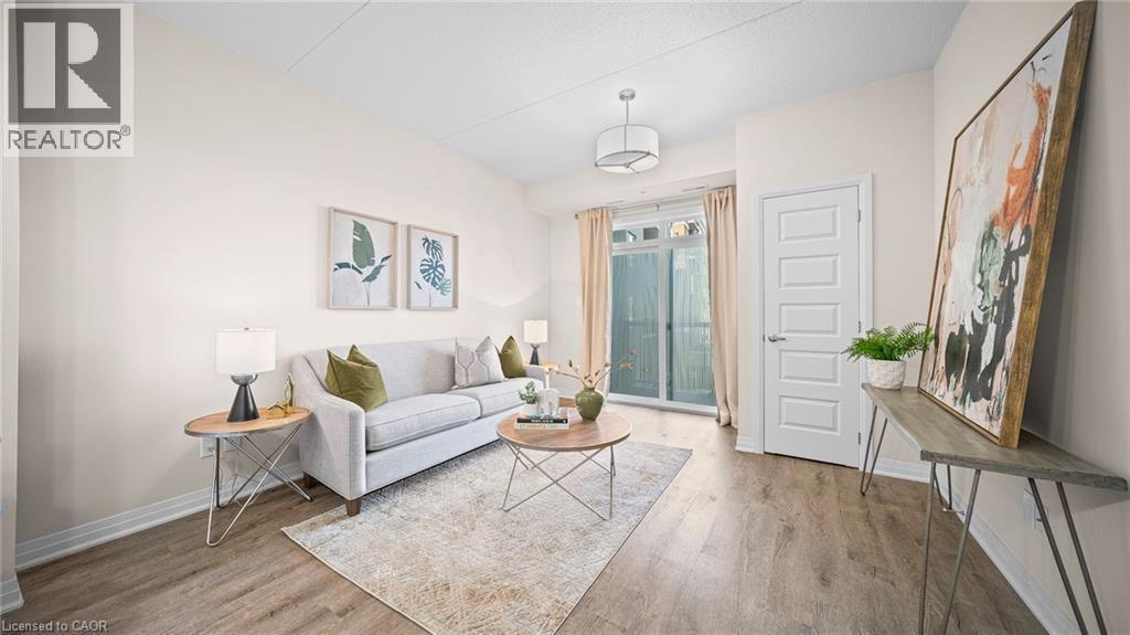 Living room featuring light wood finished floors and baseboards - 610 Farmstead Drive Unit# 304, Milton, ON - Indoor Photo Showing Living Room