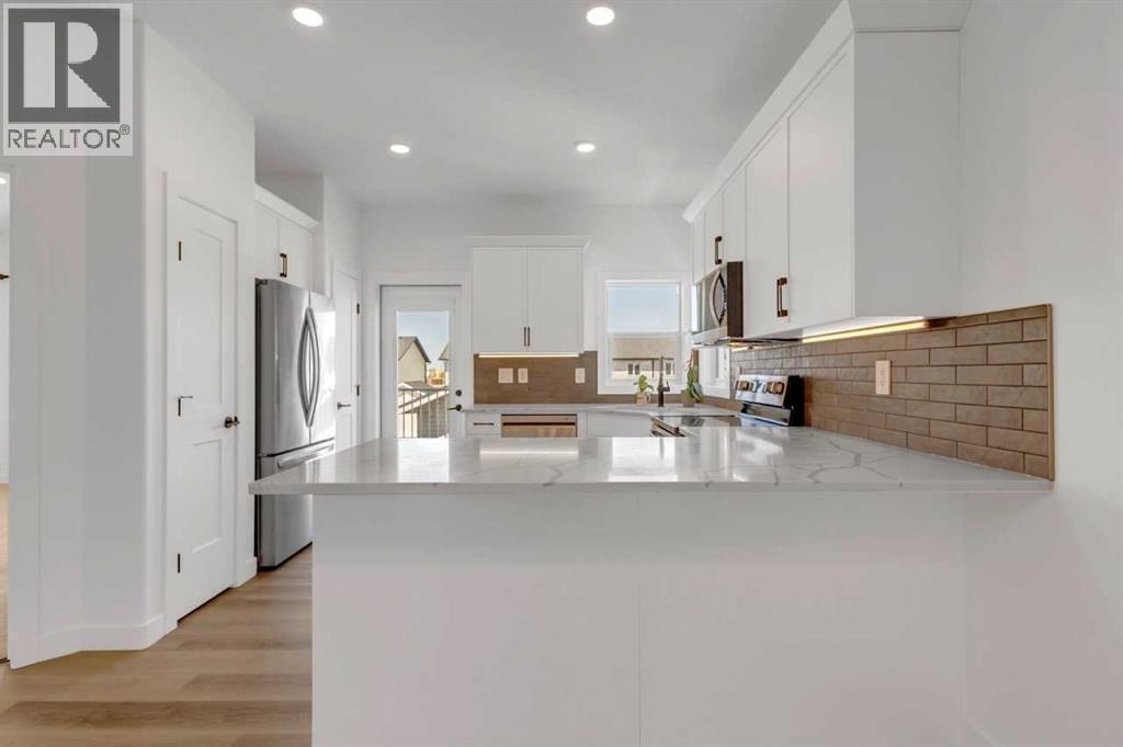 Exit to Deck - 9 Ian Way, Sylvan Lake, AB - Indoor Photo Showing Kitchen With Double Sink With Upgraded Kitchen