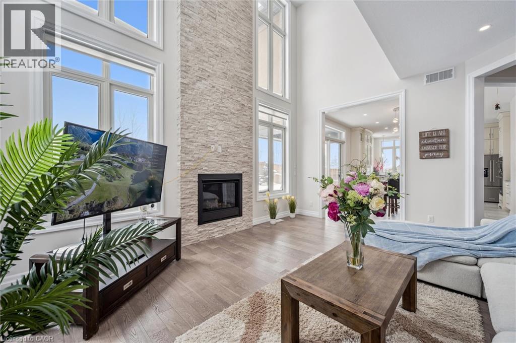 Living room featuring a fireplace, wood finished floors, and a towering ceiling - 263 Chestnut Ridge, Waterloo, ON - Indoor Photo Showing Living Room With Fireplace