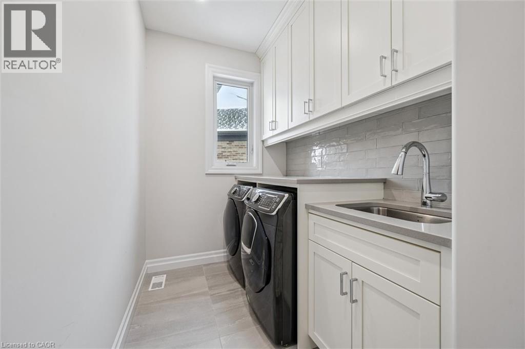 Laundry room featuring cabinet space and washing machine and dryer - 263 Chestnut Ridge, Waterloo, ON - Indoor Photo Showing Laundry Room