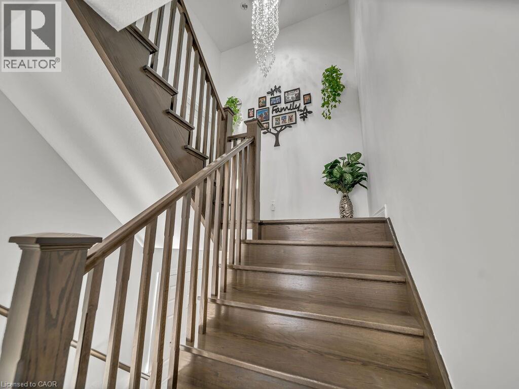 Staircase with a chandelier - 144 Summit Ridge Drive, Guelph, ON - Indoor Photo Showing Other Room