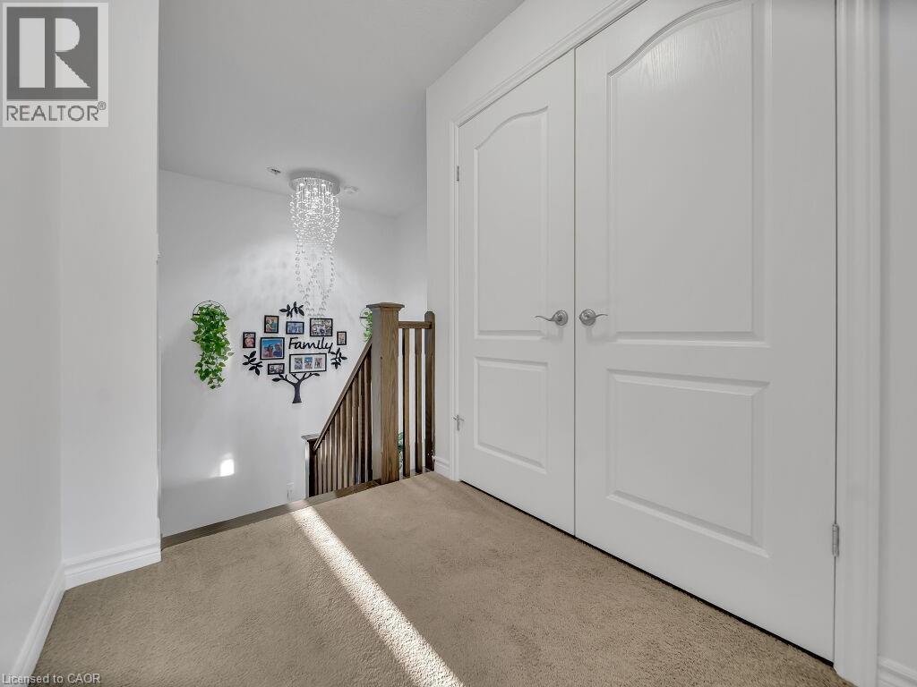 Corridor with an upstairs landing, carpet, and a chandelier - 144 Summit Ridge Drive, Guelph, ON - Indoor Photo Showing Other Room