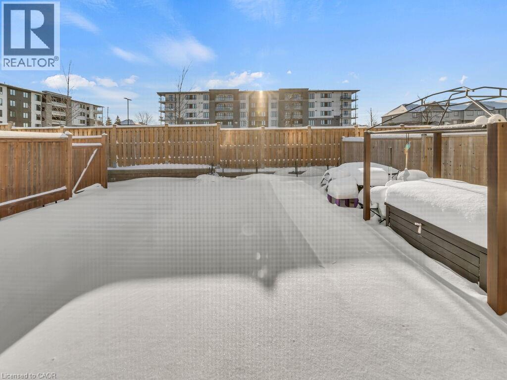 Yard layered in snow with a fenced backyard - 144 Summit Ridge Drive, Guelph, ON - Outdoor