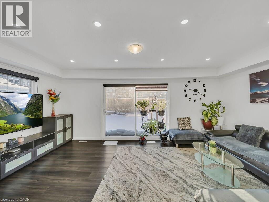 Living room with dark wood-style floors and recessed lighting - 144 Summit Ridge Drive, Guelph, ON - Indoor Photo Showing Living Room