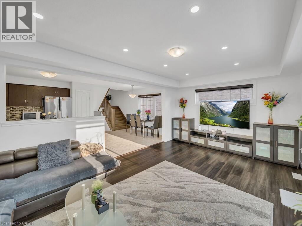 Living area featuring dark wood-type flooring, stairway, a raised ceiling, and recessed lighting - 144 Summit Ridge Drive, Guelph, ON - Indoor Photo Showing Living Room