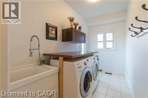 Laundry room with light tile patterned floors and washing machine and dryer - 158 River Run Road, Drayton, ON - Indoor Photo Showing Laundry Room