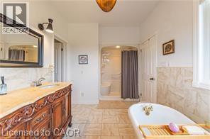 Bathroom with a freestanding bath, double vanity, and a walk in shower - 158 River Run Road, Drayton, ON - Indoor Photo Showing Bathroom