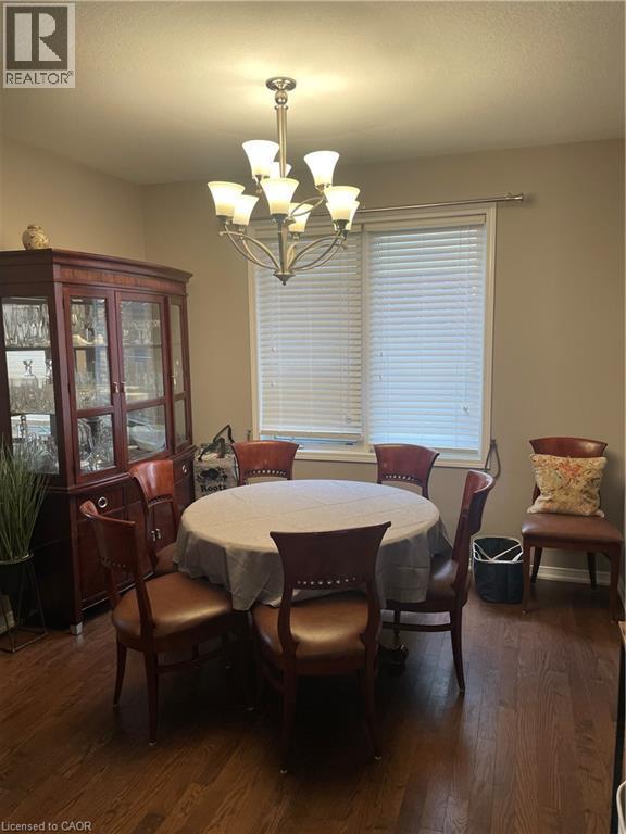 Dining space with a chandelier, dark wood-style floors, and a textured ceiling - 229 Pine Glen Crescent, Kitchener, ON - Indoor Photo Showing Dining Room