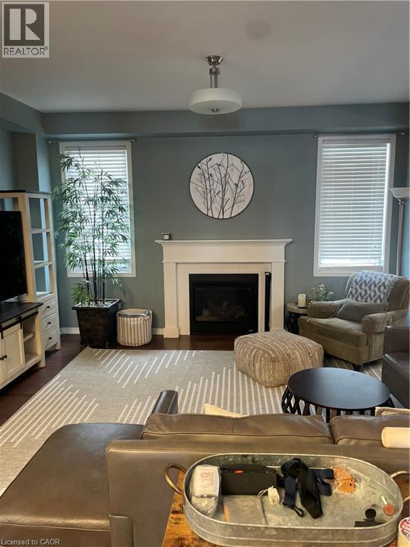 Living area with a fireplace and dark wood-type flooring - 229 Pine Glen Crescent, Kitchener, ON - Indoor Photo Showing Living Room With Fireplace