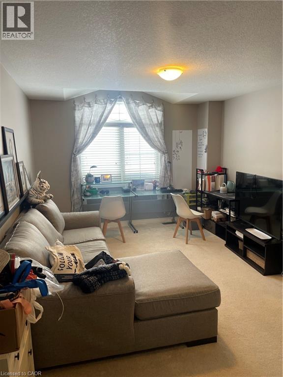 Living area featuring a textured ceiling and carpet floors - 229 Pine Glen Crescent, Kitchener, ON - Indoor Photo Showing Living Room