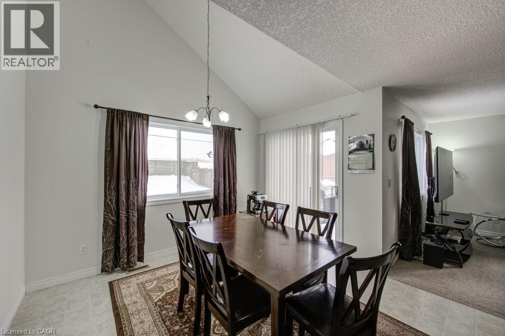 Dining room with a chandelier and high vaulted ceiling - 711 Southwood Way, Woodstock, ON - Indoor Photo Showing Dining Room