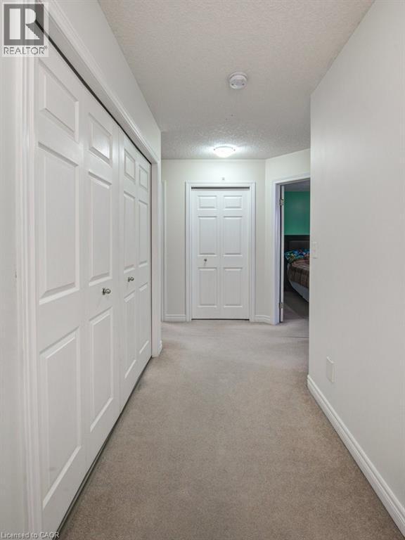 Hall with a textured ceiling and light carpet - 711 Southwood Way, Woodstock, ON - Indoor Photo Showing Other Room