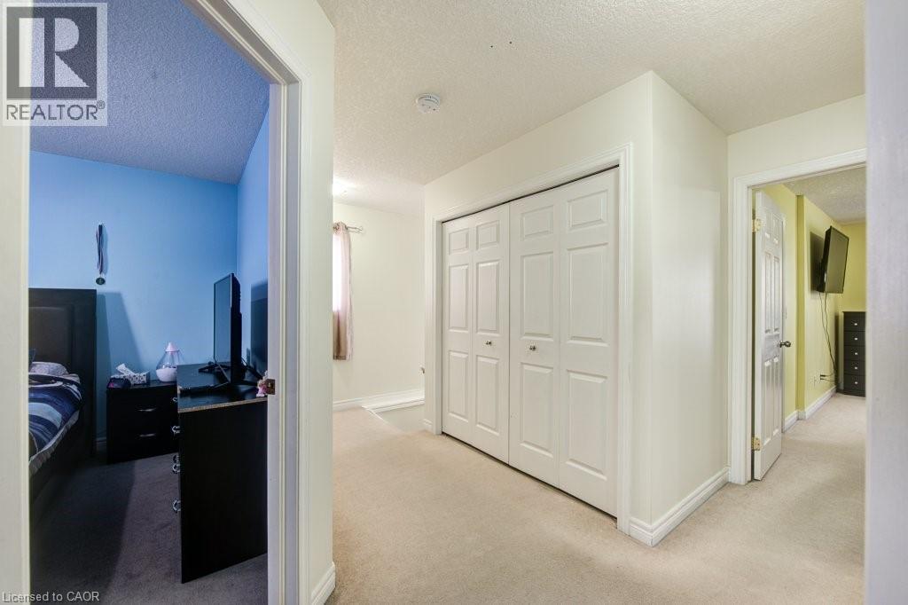 Corridor with a textured ceiling and light colored carpet - 711 Southwood Way, Woodstock, ON - Indoor Photo Showing Other Room