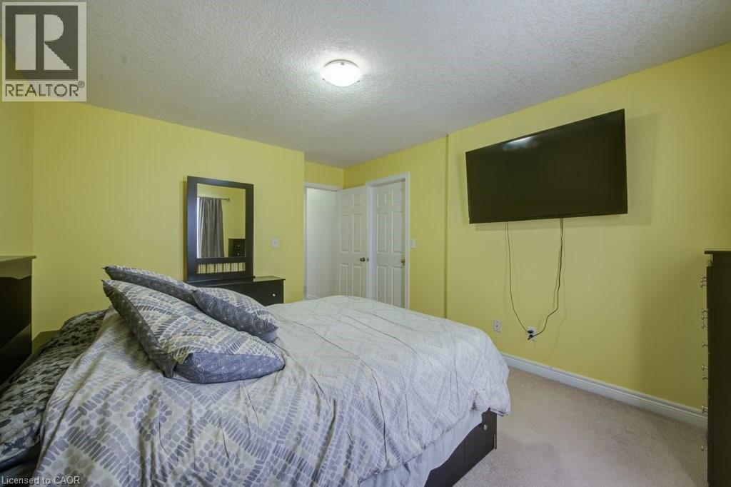 Bedroom featuring a textured ceiling and carpet flooring - 711 Southwood Way, Woodstock, ON - Indoor Photo Showing Bedroom