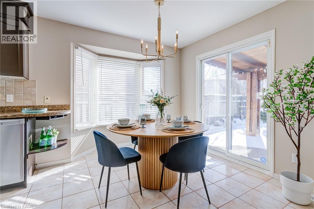 Dining area with light tile patterned flooring and a chandelier - 15 Claudette Gate, Hamilton, ON - Indoor Photo Showing Dining Room