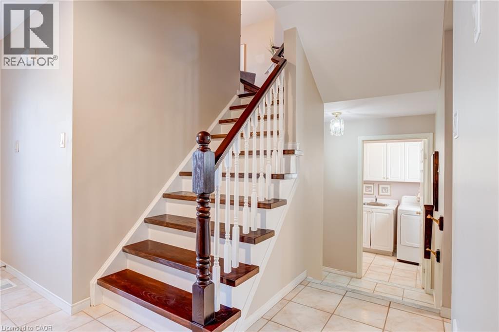 Staircase featuring tile patterned floors and washer / dryer - 15 Claudette Gate, Hamilton, ON - Indoor Photo Showing Other Room