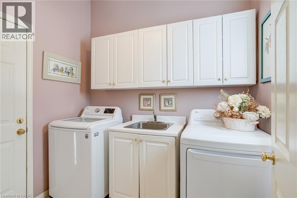 Laundry room featuring washer and dryer and cabinet space - 15 Claudette Gate, Hamilton, ON - Indoor Photo Showing Laundry Room