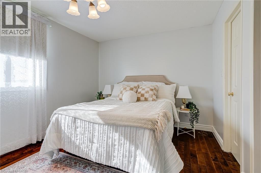 Bedroom with dark wood finished floors and a chandelier - 15 Claudette Gate, Hamilton, ON - Indoor Photo Showing Bedroom
