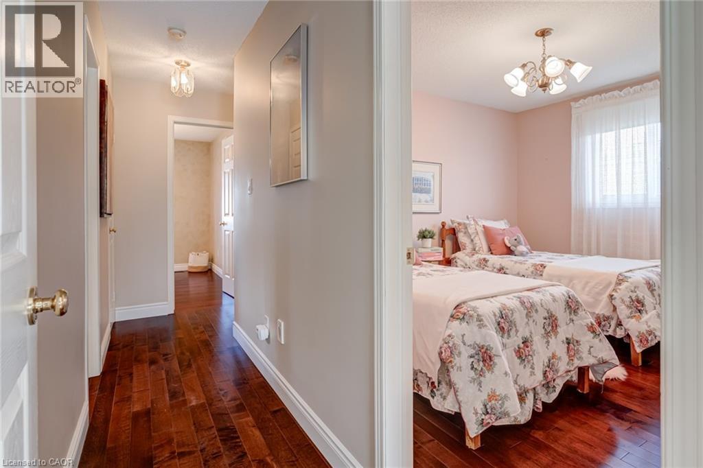 Bedroom with a chandelier and dark wood-style floors - 15 Claudette Gate, Hamilton, ON - Indoor