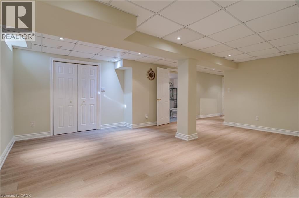 Finished basement with a drop ceiling and light wood-type flooring - 15 Claudette Gate, Hamilton, ON - Indoor