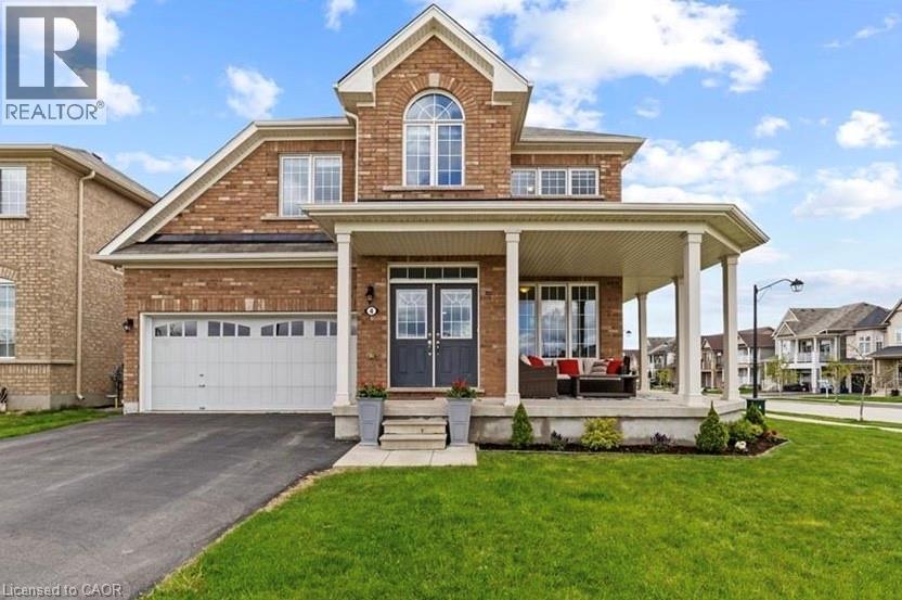 View of front of house featuring a porch, asphalt driveway, a front yard, a garage, and brick siding - 4 Tinlin Drive, Binbrook, ON - Outdoor With Facade
