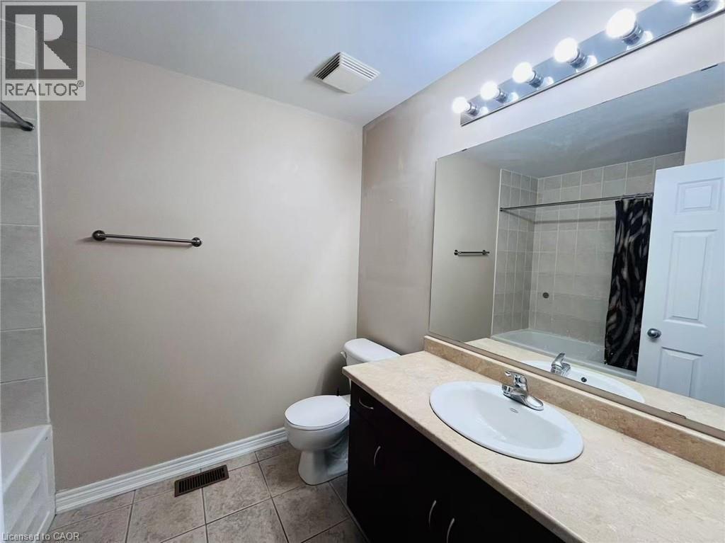 Bathroom with shower / bathtub combination with curtain, vanity, and light tile patterned floors - 5053 Bidwell Common, Burlington, ON - Indoor Photo Showing Bathroom