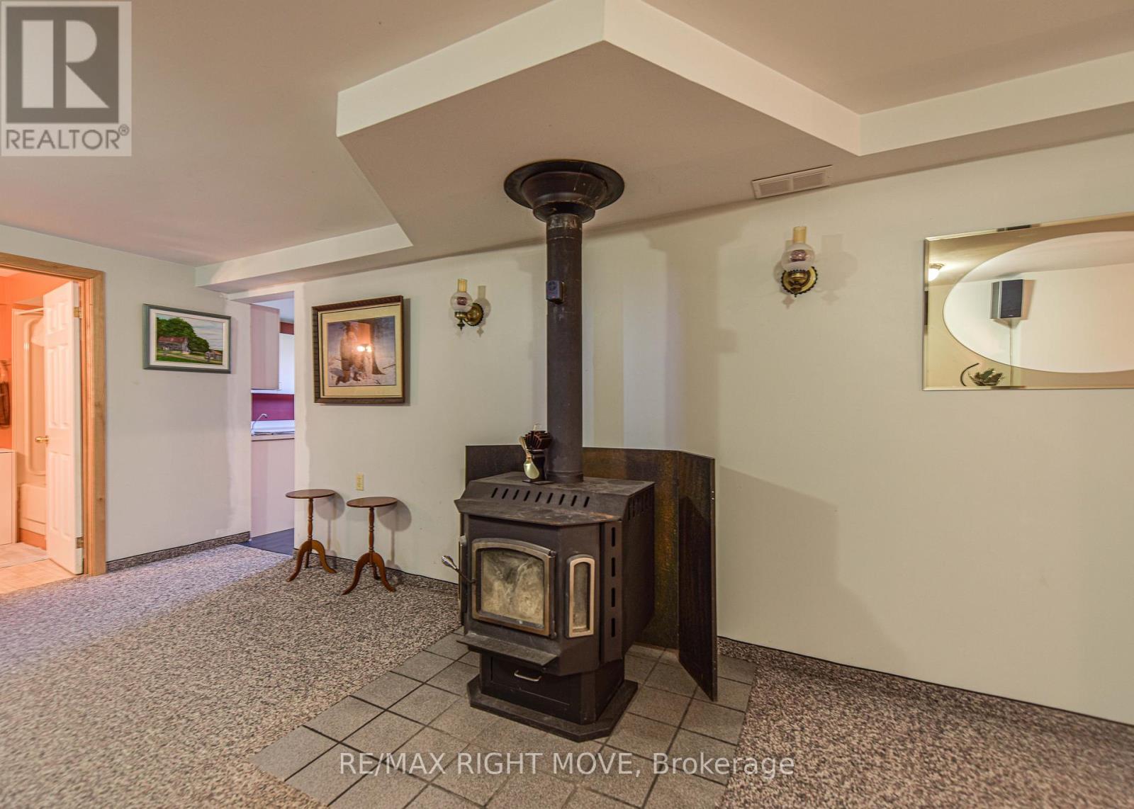 Wood fireplace on lower level - 2723 Monck Road, Ramara, ON - Indoor Photo Showing Other Room