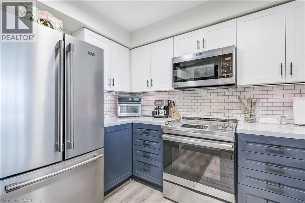 Kitchen featuring appliances with stainless steel finishes, white cabinetry, and decorative backsplash - 3845 Lakeshore Boulevard W Unit# 804, Etobicoke, ON - Indoor Photo Showing Kitchen With Stainless Steel Kitchen