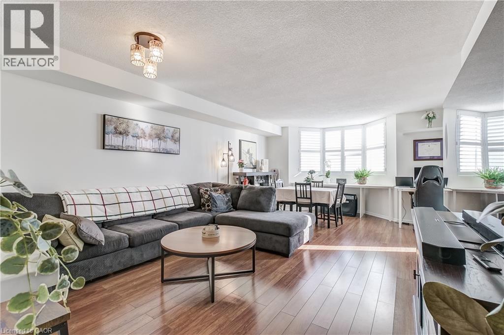 Living area featuring hardwood / wood-style floors, a textured ceiling, and healthy amount of natural light - 3845 Lakeshore Boulevard W Unit# 804, Etobicoke, ON - Indoor Photo Showing Living Room