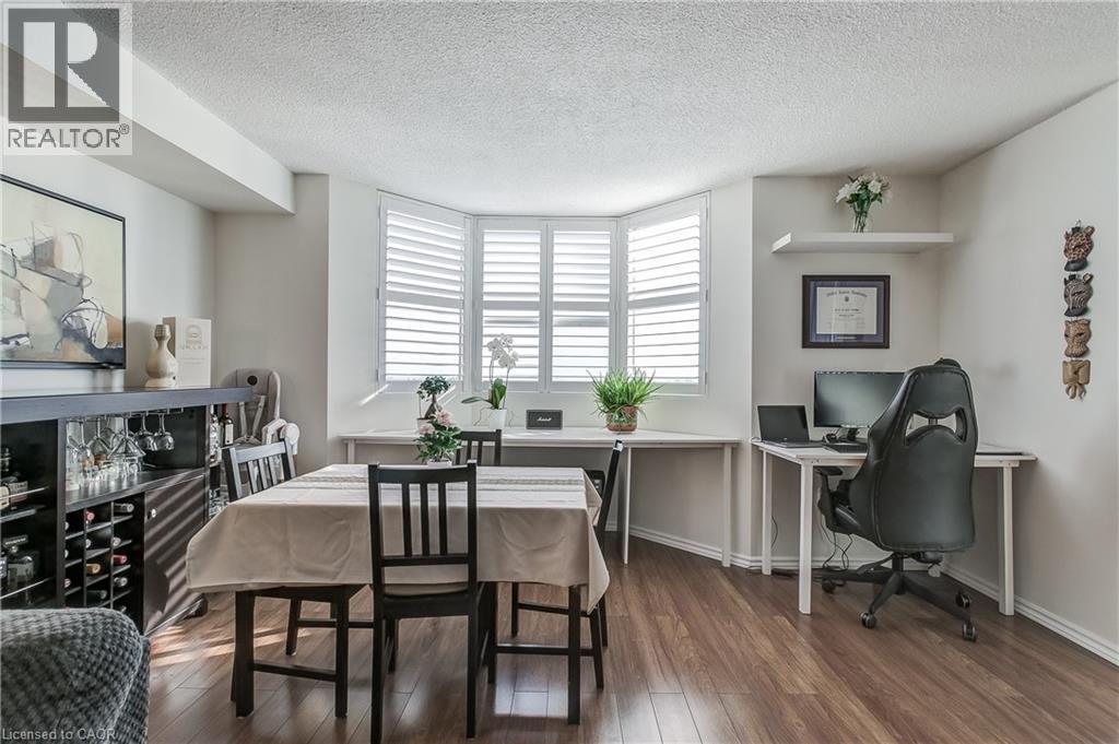 Dining area featuring dark wood-style floors, a textured ceiling, and an office area - 3845 Lakeshore Boulevard W Unit# 804, Etobicoke, ON - Indoor Photo Showing Dining Room
