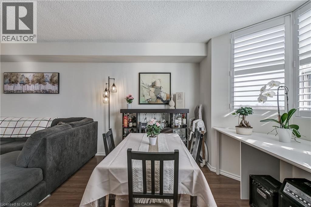 Dining area featuring dark wood-style flooring and a textured ceiling - 3845 Lakeshore Boulevard W Unit# 804, Etobicoke, ON - Indoor Photo Showing Dining Room