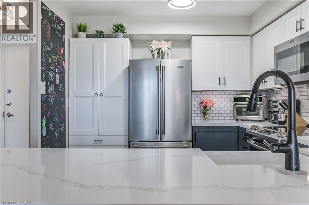 Kitchen with white cabinets, appliances with stainless steel finishes, light stone countertops, tasteful backsplash, and gray cabinets - 3845 Lakeshore Boulevard W Unit# 804, Etobicoke, ON - Indoor Photo Showing Kitchen