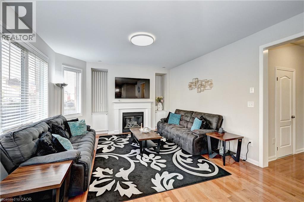Living room with light wood-style floors and a glass covered fireplace - 32 Weir Street, Cambridge, ON - Indoor Photo Showing Living Room With Fireplace
