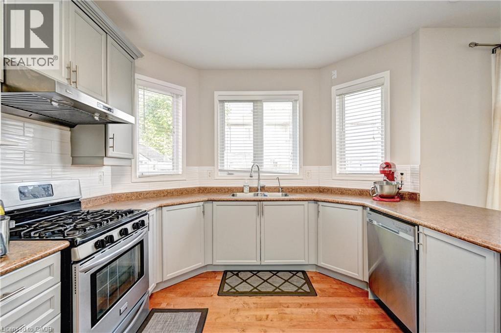 Kitchen featuring appliances with stainless steel finishes, under cabinet range hood, healthy amount of natural light, and light wood-type flooring - 32 Weir Street, Cambridge, ON - Indoor Photo Showing Kitchen With Double Sink