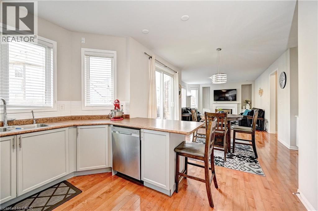 Kitchen with a peninsula, light wood-style floors, pendant lighting, and dishwasher - 32 Weir Street, Cambridge, ON - Indoor Photo Showing Kitchen